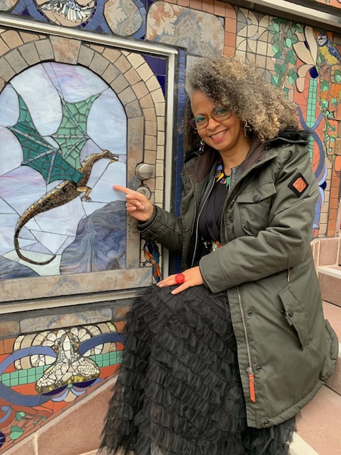 Natlie pointing towards a Dragon from window view mosaic art